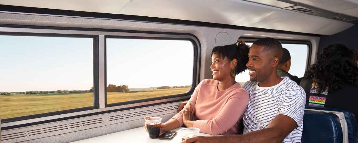 Couple enjoying scenic views from Train Reservation Desk cafe car